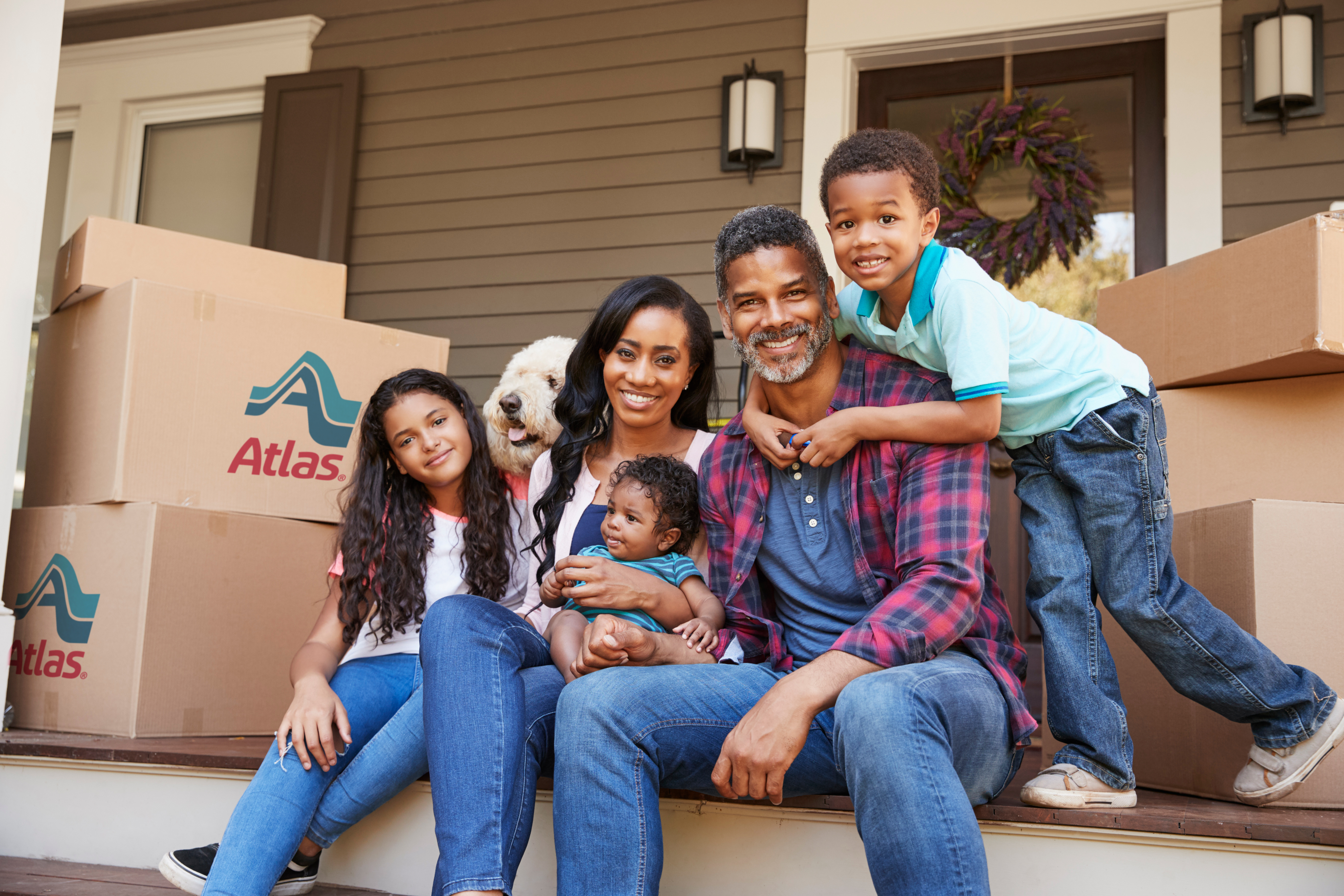 Atlas-Family-on-porch-with-boxes.jpg