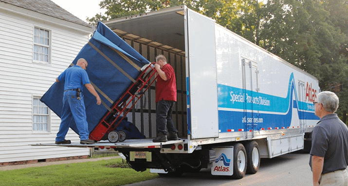 Movers unloading items off back of moving truck